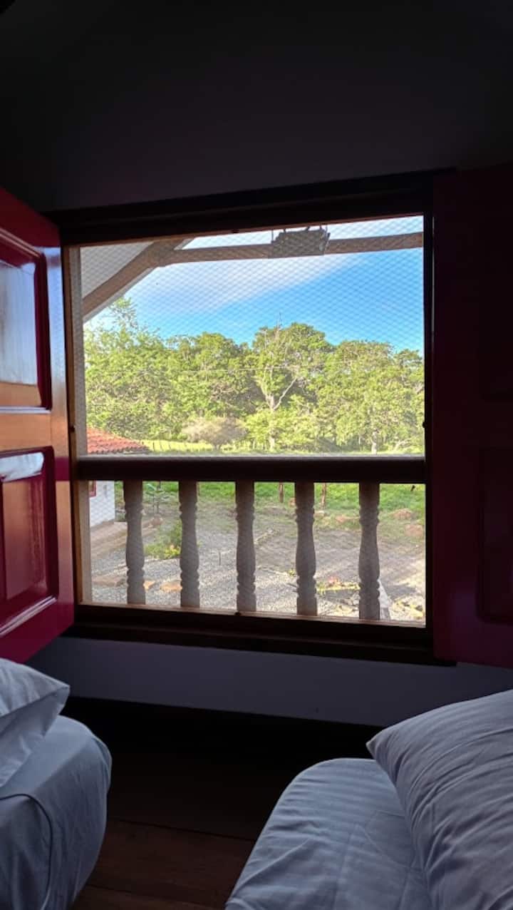 La habitación N. 2, es un altillo en madera que cuenta con 2 nidos sencillos para su descanso; su acceso es a través de una escalera en madera de mas o menos 12 escalones; sus ventanas aledañas cuentan con angeo para evitar los insectos.