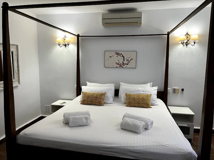 להירגע בחדר השינה המרווח הזה עם מיטת קינג סייז מפוארת ונוף לגינה הפרטית ולבריכה.