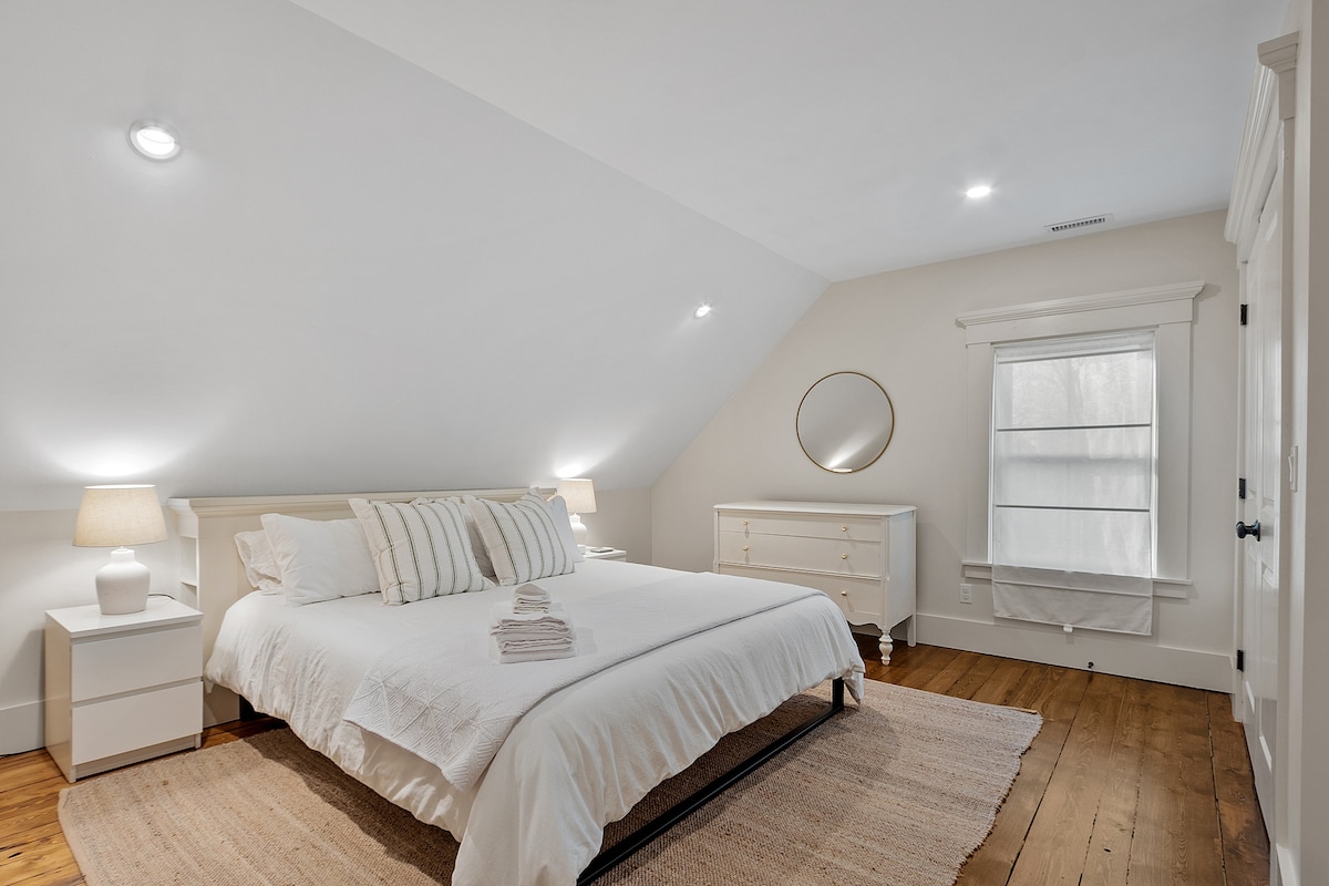 Chumba kikuu cha kulala chenye kitanda na kabati la ukubwa wa kifalme, lililo kwenye ghorofa ya pili.