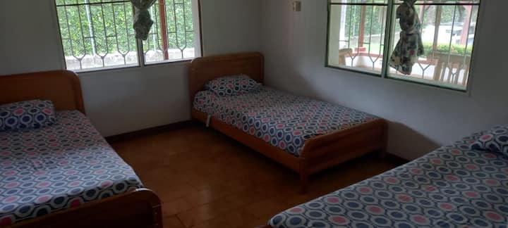 3 camas sencillas en madera, ventilador de techo y baño compartido entre 2 habitaciones con puerta independiente