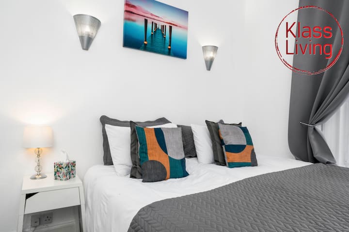 Útulná spálňa v Klass Living Short Lets & Serviced Accommodation Bellshill spája pohodlie so súčasným štýlom pre relaxačný a príjemný pobyt.