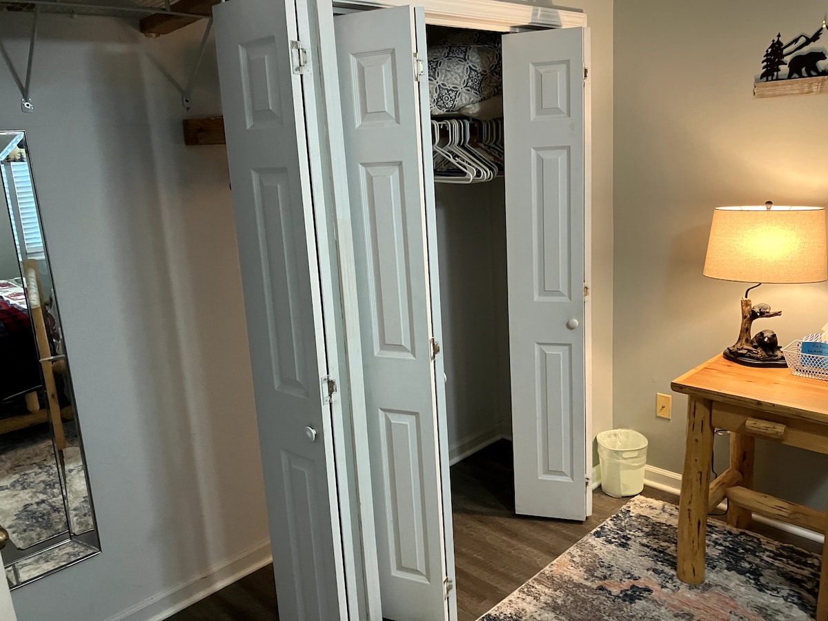 ארון בגדים לבן מרווח עם דלתות מתקפלות ומרآה בגובה מלא - מושלם לבדיקת התלבושת שלכם! פתרון האחסון המסוגנן הזה מוסיף נוחות ונוחות לנופש שלכם בהרי הסמוקי.
