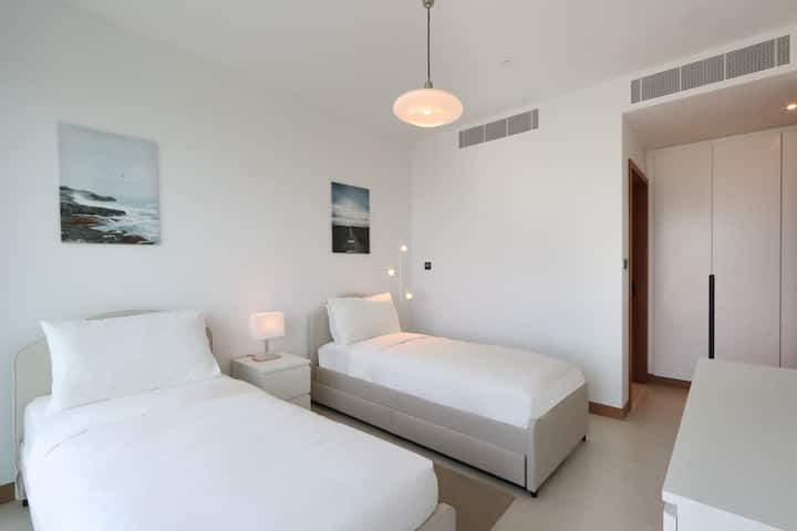 ห้องนอนคู่สว่างพร้อมแสงไฟอ่อนๆ และการตกแต่งแบบมินิมอล