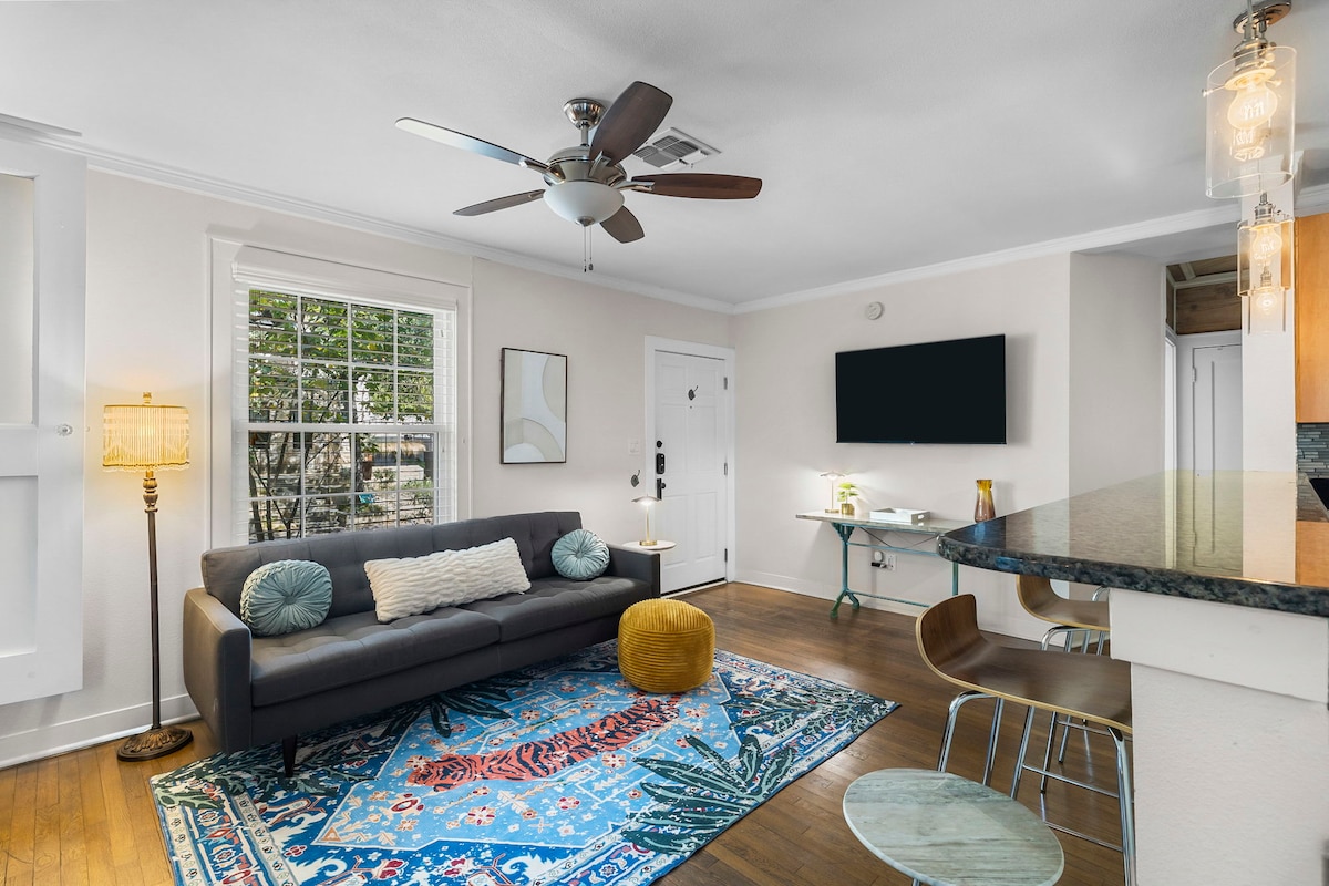 Pumzika katika sebule yenye starehe yenye mwangaza laini, viti vya kifahari na televisheni mahiri kwenye mkono wa kuteleza kwa ajili ya kutazama kwa urahisi