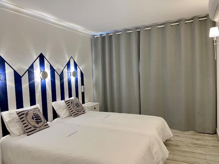 Dhomë gjumi e madhe me perde errësuese për një gjumë të mirë. Kondicioner, detaje dekorative 