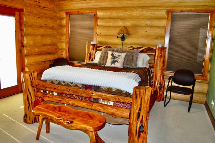 Hlavná spálňa s manželskou posteľou.  Dvere vedúce na zadnú terasu.