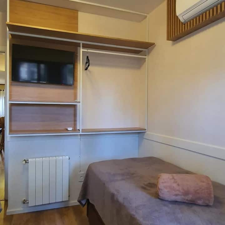 Quarto com 3 camas de solteiro. Com televisão e ar condicionado.