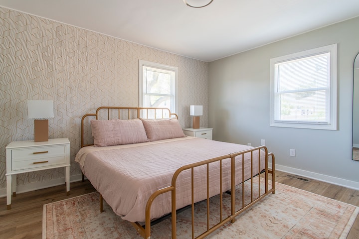 غرفة النوم المريحة هذه مجهزة للضيوف مع مفارش جديدة وإضاءة عملية وتصميم نظيف وبسيط.