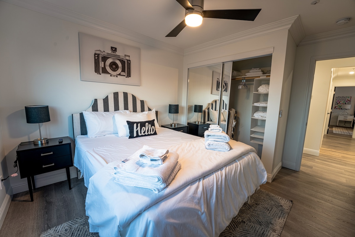 Bedroom #2 complete with: Queen-sized bed, flatscreen TV & a single-sized folding bed