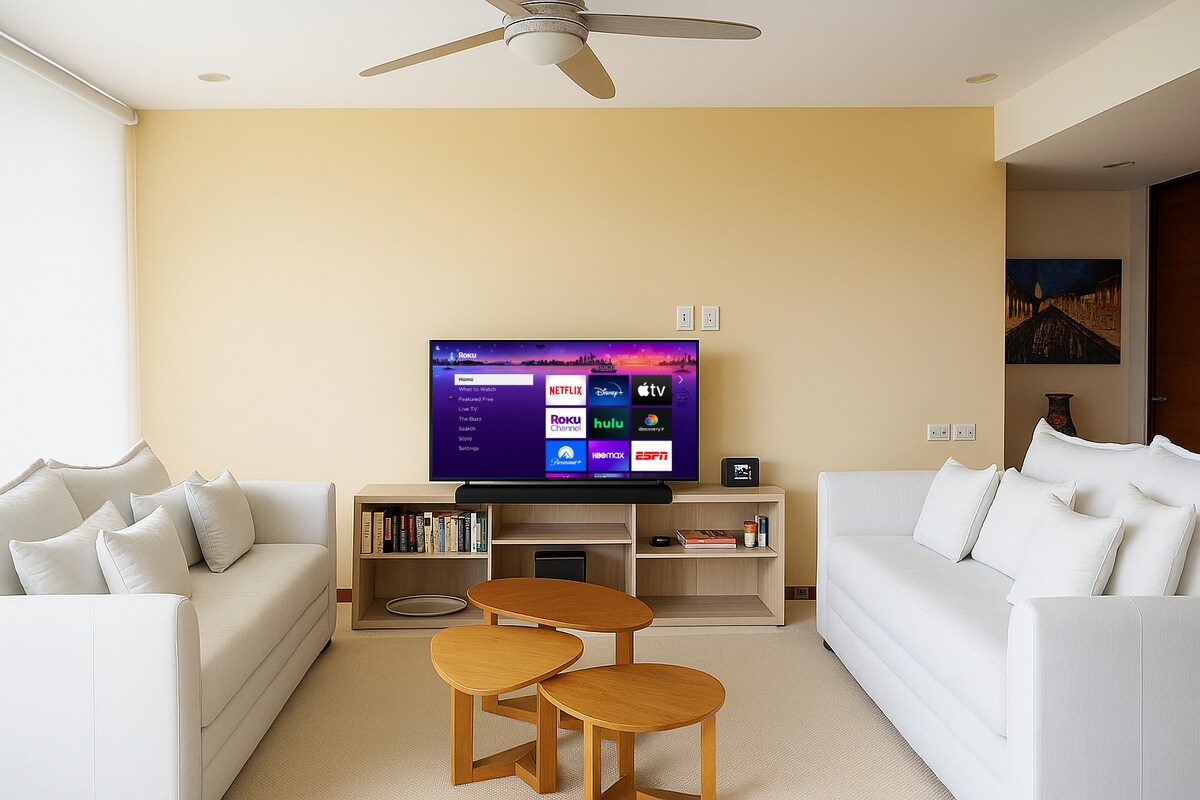 Sala con dos sofá camas, equipo de sonido y televisión smart.