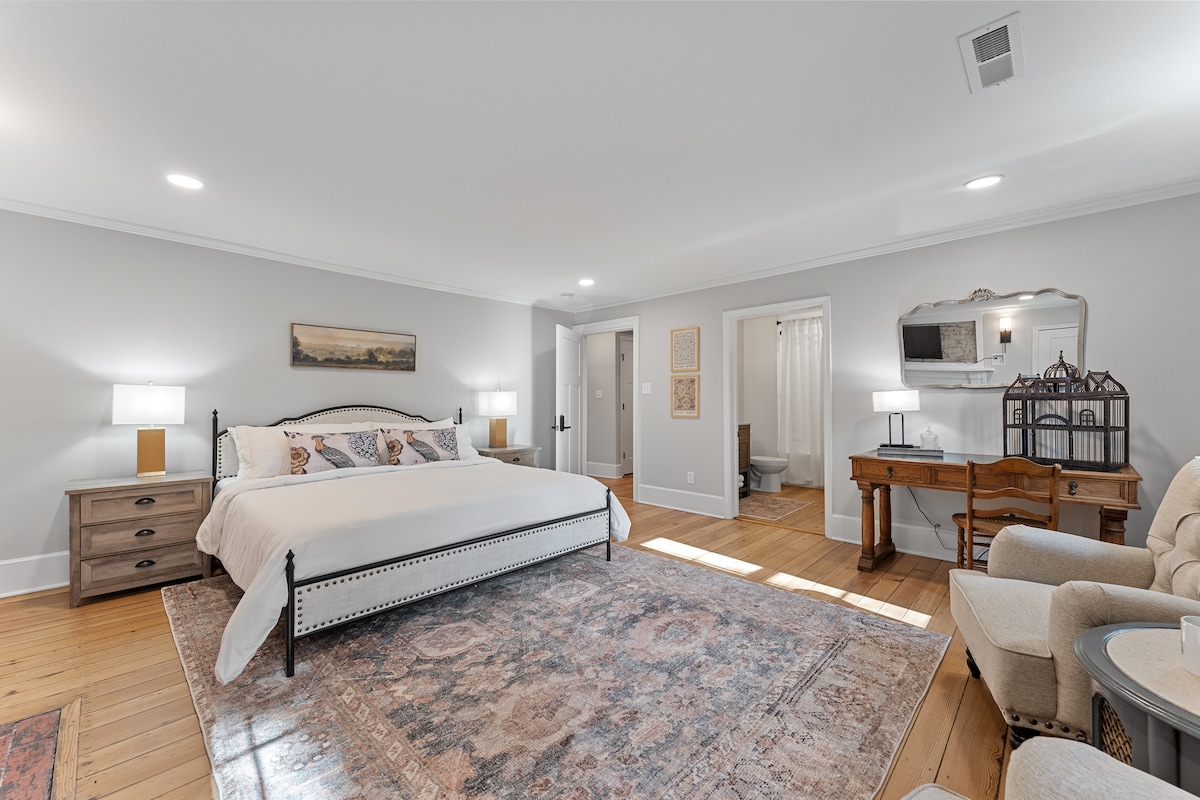 Relax in this oversized bedroom with a king bed, cozy gas fireplace, private bathroom, and modern amenities like a TV, desk, and Nespresso machine. Perfect for a comfortable stay.