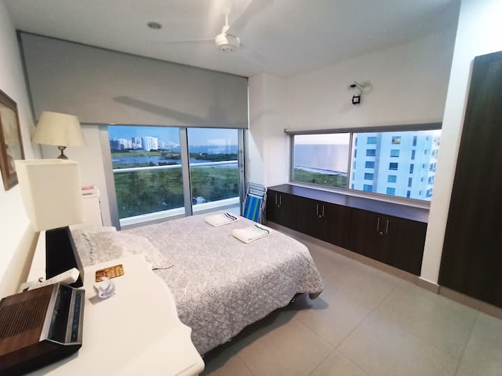 Imagina despertar con una vista exuberante a la sierra por un lado y al horizonte del mar por el otro. Descansa en una cama grande con colchón de firmeza media y una capa de vixcolatex. Además, cajoneros, aire acondicionado y tu propio balcón.