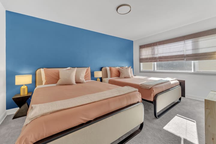 Спална соба со два удобни кревета наспроти неверојатни сини ѕидови