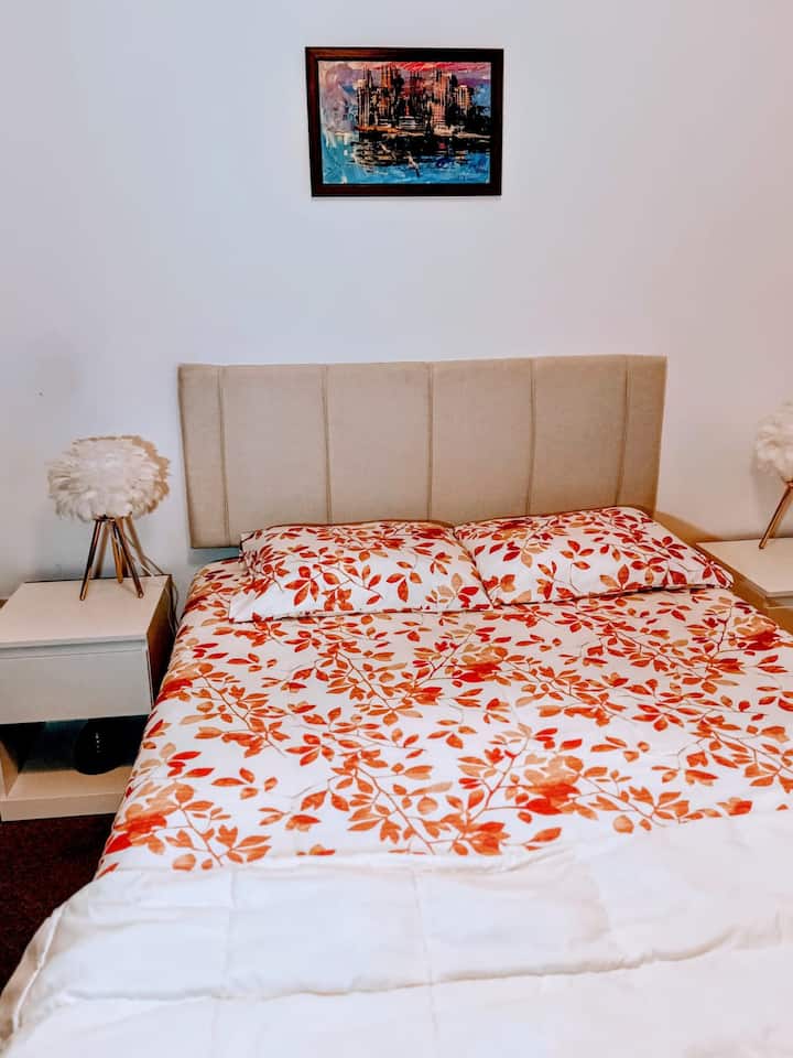 Udobna spavaća soba, lijepa i prostrana, s bračnim krevetom, ormarom od poda do stropa, velikim prozorom, radnim prostorom s radnim stolom i stolicom, uključuje aparat za kavu, Dolce Gusto, TV s Rokuom, kontrolu intenziteta svjetlosti.