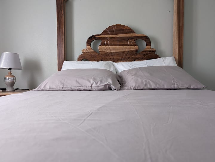 ห้องนอนที่สะดวกสบายเตียงควีนไซส์พร้อมหมอน 4 ใบโต๊ะข้างเตียงโคมไฟตู้เสื้อผ้าเตารีดโต๊ะรีดผ้าตะกร้าซักผ้าและเครื่องปรับอากาศ 