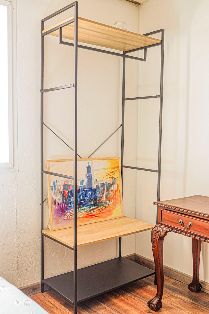 FR : Coin au charme artistique, mêlant meuble moderne et table ancienne pour une élégante touche vintage dans la chambre

ANG : A corner with artistic charm, combining modern furniture and an antique table for an elegant vintage touch in the bedroom