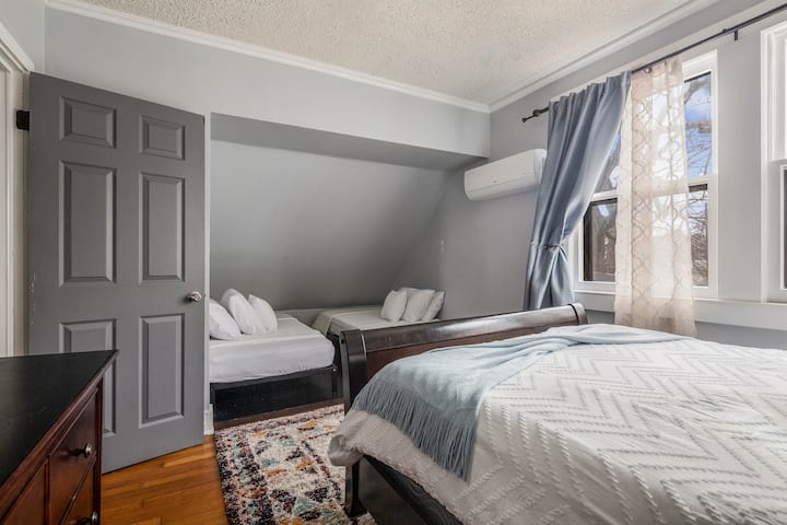 غرفة النوم 2 في المنزل مع سرير كبير وسريرين مزدوجين وتلفزيون وخزانة ملابس وخزانة ملابس.