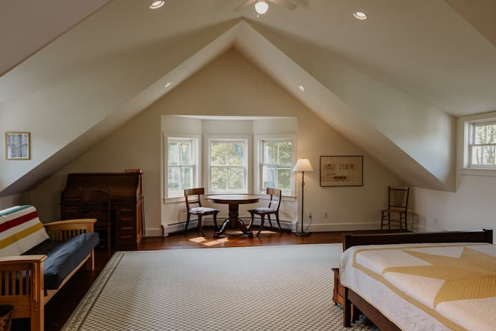Large sun-filled room with cathedral ceilings and overhead fan. A table for gathering with a puzzle, a desk for writing, space for yoga, a futon couch and a full-sized bed - a second story room with many options to suit your needs!
