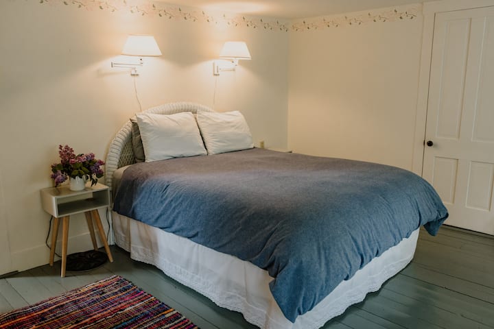 2nd floor bedroom with queen bed, bedside tables and lamps, and two spacious closets with hangers.