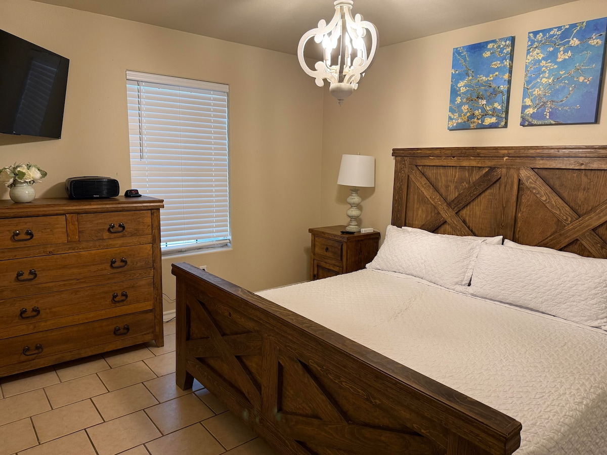 El dormitorio principal cuenta con una cama tamaño king en un entorno rústico y romántico con TV.