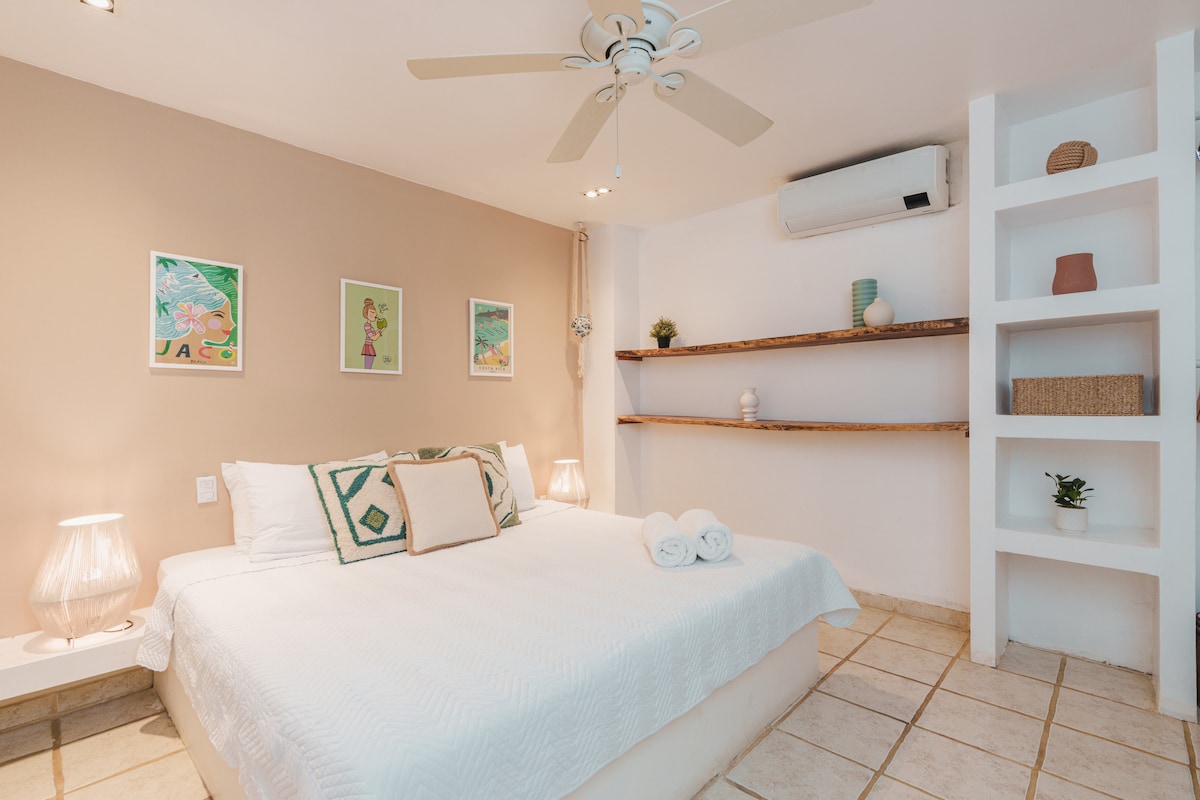 Un dormitorio cálido y acogedor adornado con una decoración suave y acogedora, con una lujosa cama tamaño king que promete noches de descanso. Un baño está convenientemente ubicado cerca, lo que se suma a la comodidad y funcionalidad de este dormitorio.