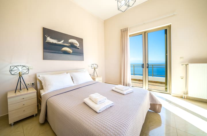 Upper Level: Master bedroom 1 with queen bed, ensuite bathroom and private balcony with sea view