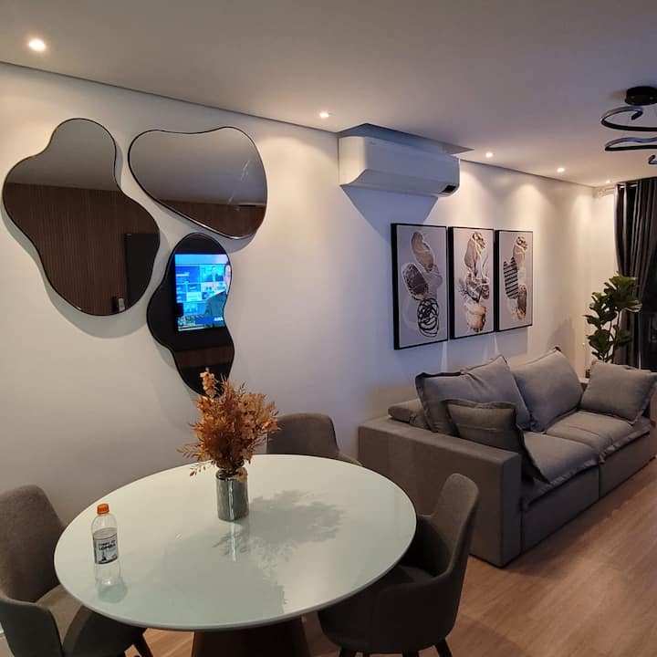 Მისაღები ოთახი მრგვალი მაგიდით 4 ადამიანისთვის. Კონდიციონერი, შეშის ბუხარი, სუპერ კომფორტული გამოსაქრობი დივანი, 65-დუიმიანი სმარტ-ტელევიზორი, პატარა აივანი  და უშუქო ფარდა, თუ მისაღებ ოთახში დაძინებას გადაწყვეტენ.