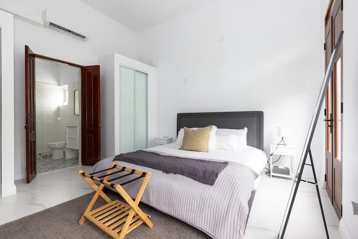 Welcome to a serene retreat with a plush king bed and minimalist decor. Enjoy the luxury of an en-suite bathroom and ample storage, all bathed in soft natural light. Perfect for a tranquil and sophisticated stay.
