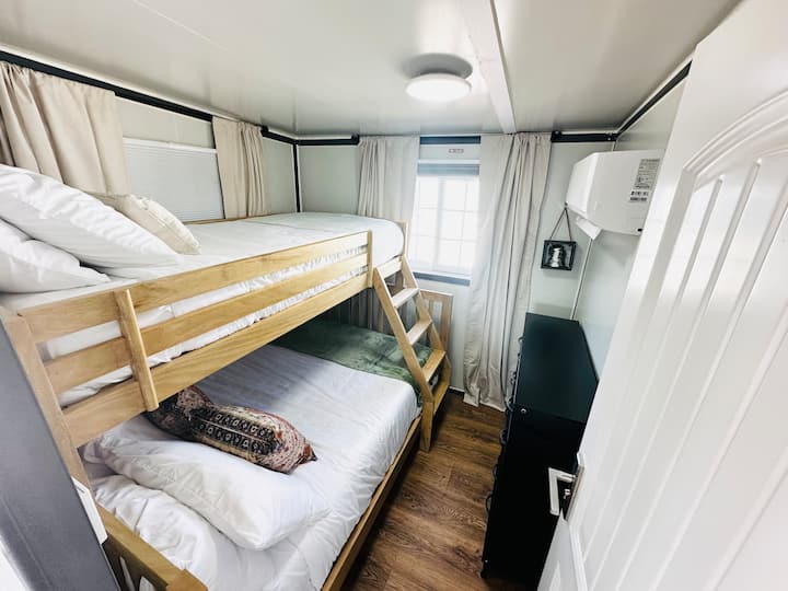 Tweepersoonsbed boven volledig stapelbed.