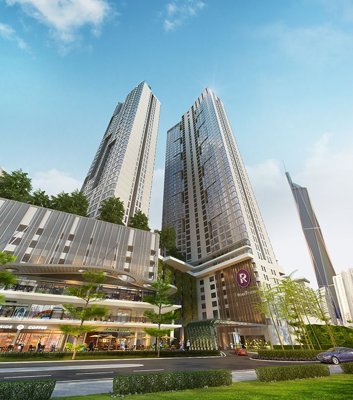 The exterior of The Resident Robertson is showcased, featuring two tall towers connected to a vibrant commercial area below. Lush greenery surrounds the entrance, with a clearly marked logo visible on the building's facade. A prominent skyscraper, likely Merdeka 118 Tower, is visible in the background.