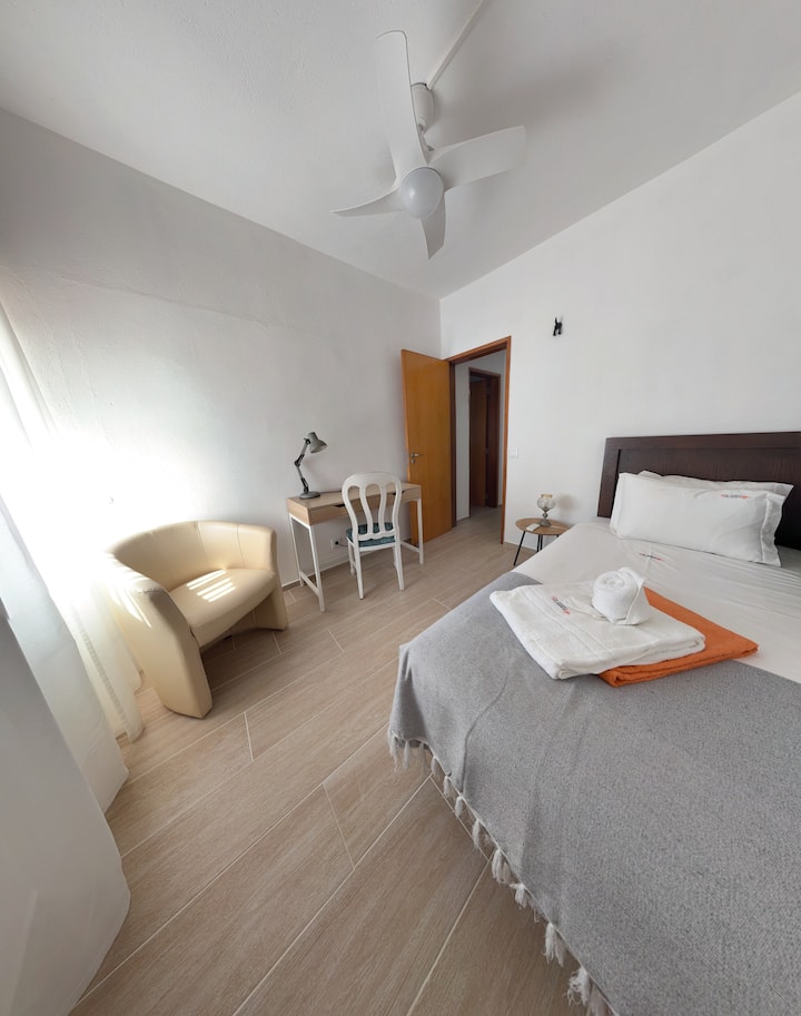 Nuestro dormitorio individual ofrece un espacio acogedor y tranquilo. También cuenta con un área de trabajo dedicada, ideal para ponerse al día con los correos electrónicos o planificar tu próxima aventura en Lagos, todo en la comodidad de tu propia habitación en Lagos Alegre Apartment. Enchufe cerca de la cama.