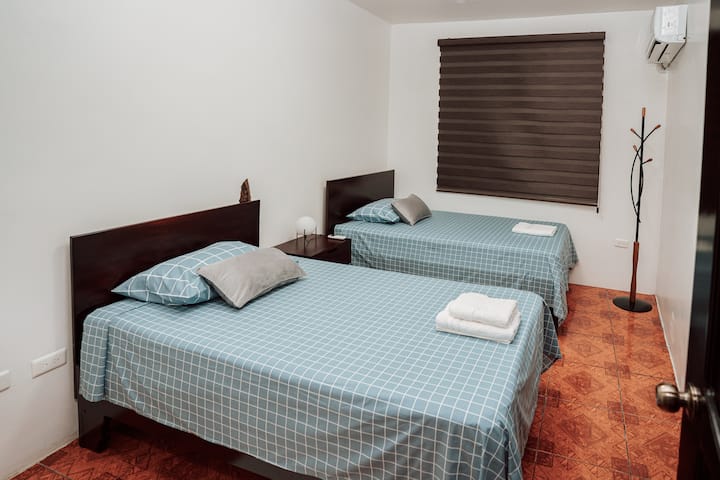 Quarto secundário com duas camas e meia quadradas, armário grande e ar condicionado