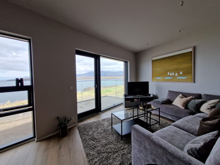 Obývacia izba s balkónom a veľkou veľmi pohodlnou pohovkou.  Televízor je v obývacej izbe, kde sa stačí prihlásiť do svojich predplatiteľských služieb.  