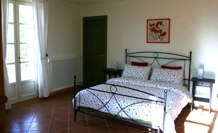 阳光明媚的1号卧室，配有标准双人床，可通过法式门进入露台。