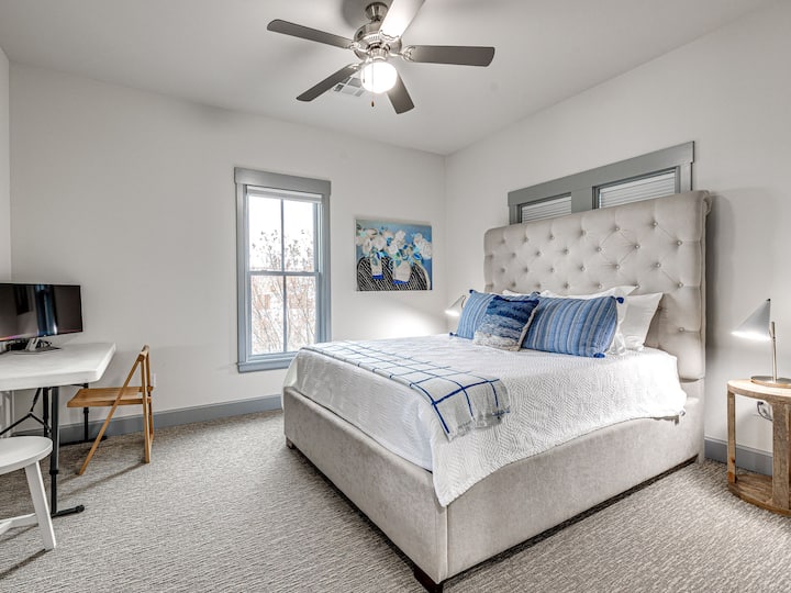 מיטת קווין עם מטענים לטלפון על שידות לילה.