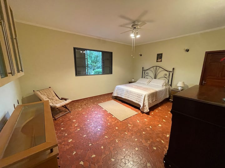 maior de todas as suítes e banheiro com box, janela com vista para a lateral da casa, para o jardim e terreiro de café.