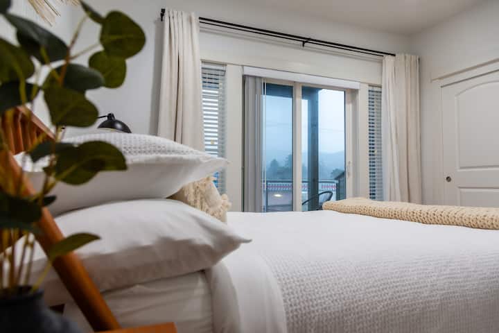 Избягайте в спокойствието в оазиса на голямата спалня с изглед към планината, оборудван със самостоятелна баня, балкон и успокояваща хидромасажна вана. 