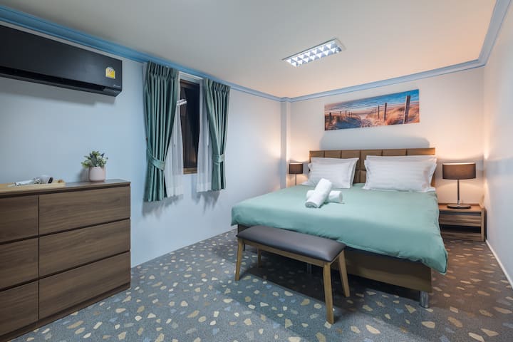 Un sereno dormitorio en la azotea adornado con un cómodo dormitorio con cama tamaño king, rodeado de una exuberante vegetación y un acceso directo al paraíso de la azotea (5th FL). 