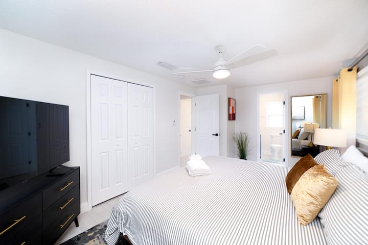 Veľká hlavná spálňa s manželskou posteľou King, priamym prístupom do kúpeľne a 55-palcovou TV