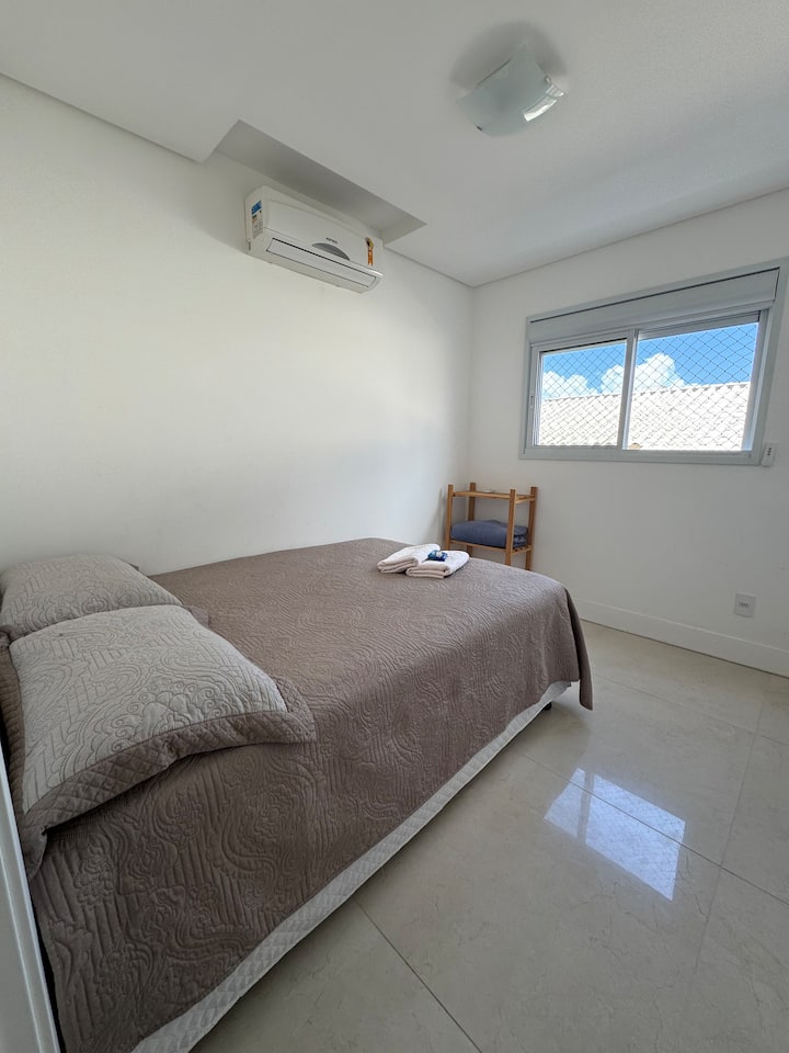 Habitación con cama matrimonial y aire acondicionado. Ventanas con persianas automáticas.