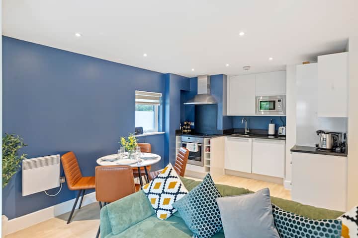 Priestranná izba s otvoreným usporiadaním s plyšovou pohovkou, jedálenským stolom, plne vybavenou kuchyňou a veľkým oknom pre prirodzené svetlo. Štýlové a lákavé.