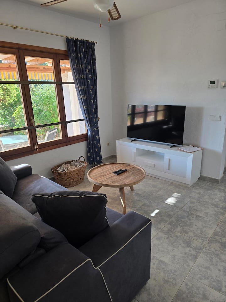 מהמטבחון אפשר להביט לסלון, עם ספה נוחה, קרדינזה וטלוויזיה. חלל רגוע ונינוח להירגע או ליהנות מסרט הרחק מהקומה הראשית.