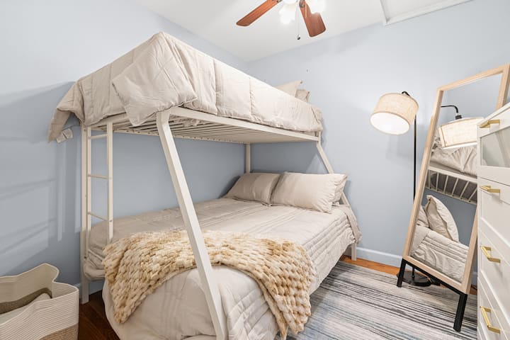Acogedora habitación con una litera doble, perfecta para niños o grupos. Incluye un espejo de cuerpo entero e iluminación suave para mayor comodidad.