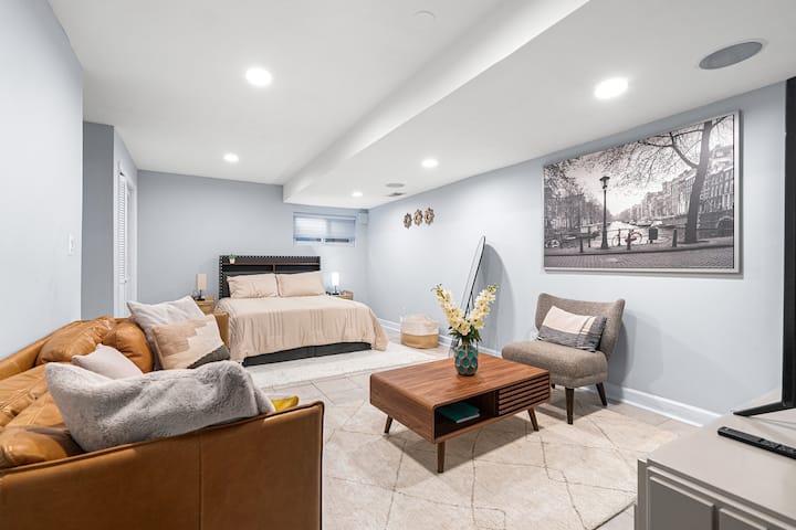 Amplia suite en el nivel inferior con una cama tamaño queen, una acogedora sala de estar y una decoración moderna perfecta para relajarse o para estancias prolongadas.