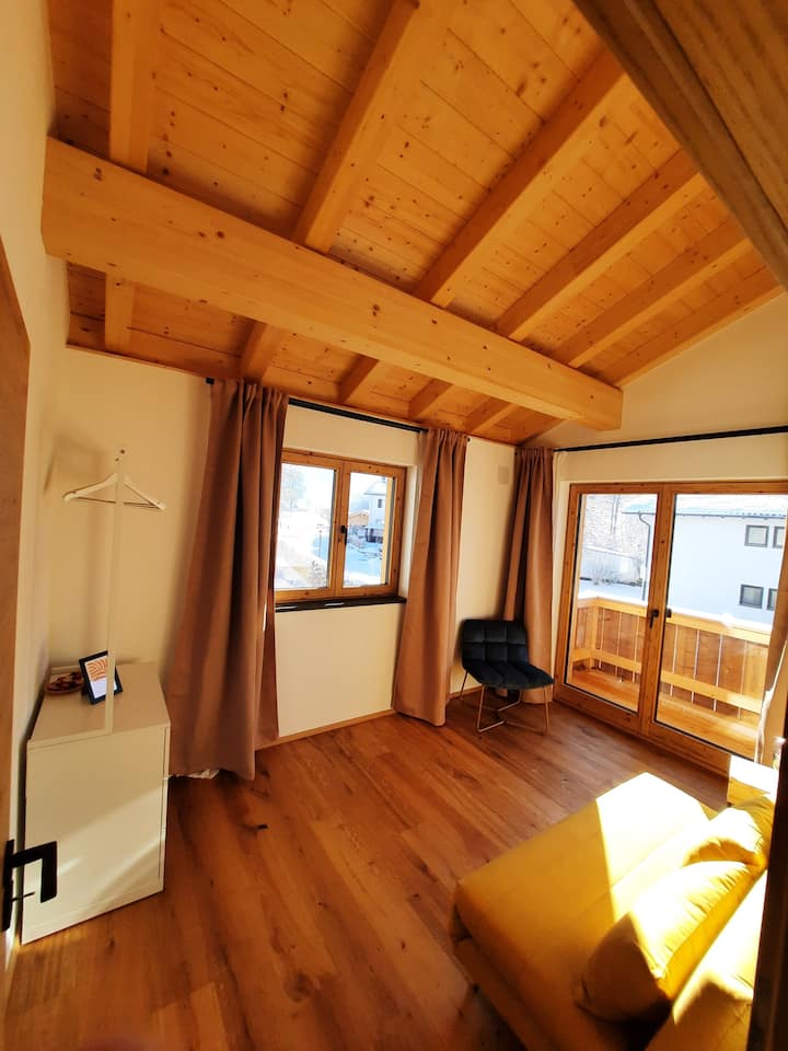 topla, šarena soba s pogledom na planine i izlazom na balkon
