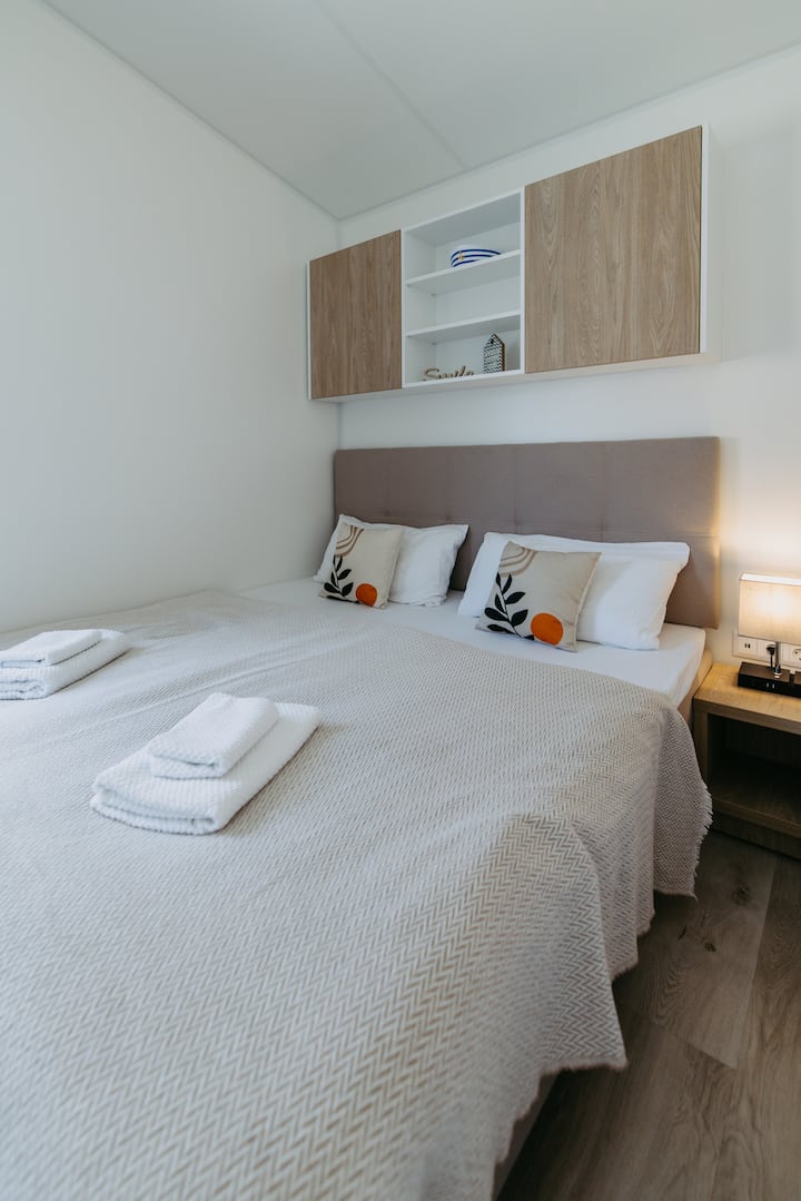 Here you will find a king-size bed (180 cm), a workstation and large cupboards. At the bedside table, you will find a socket as well as USB connections and a practical storage space for smartphones (integrated in the lamp).

Photo © wearegiving