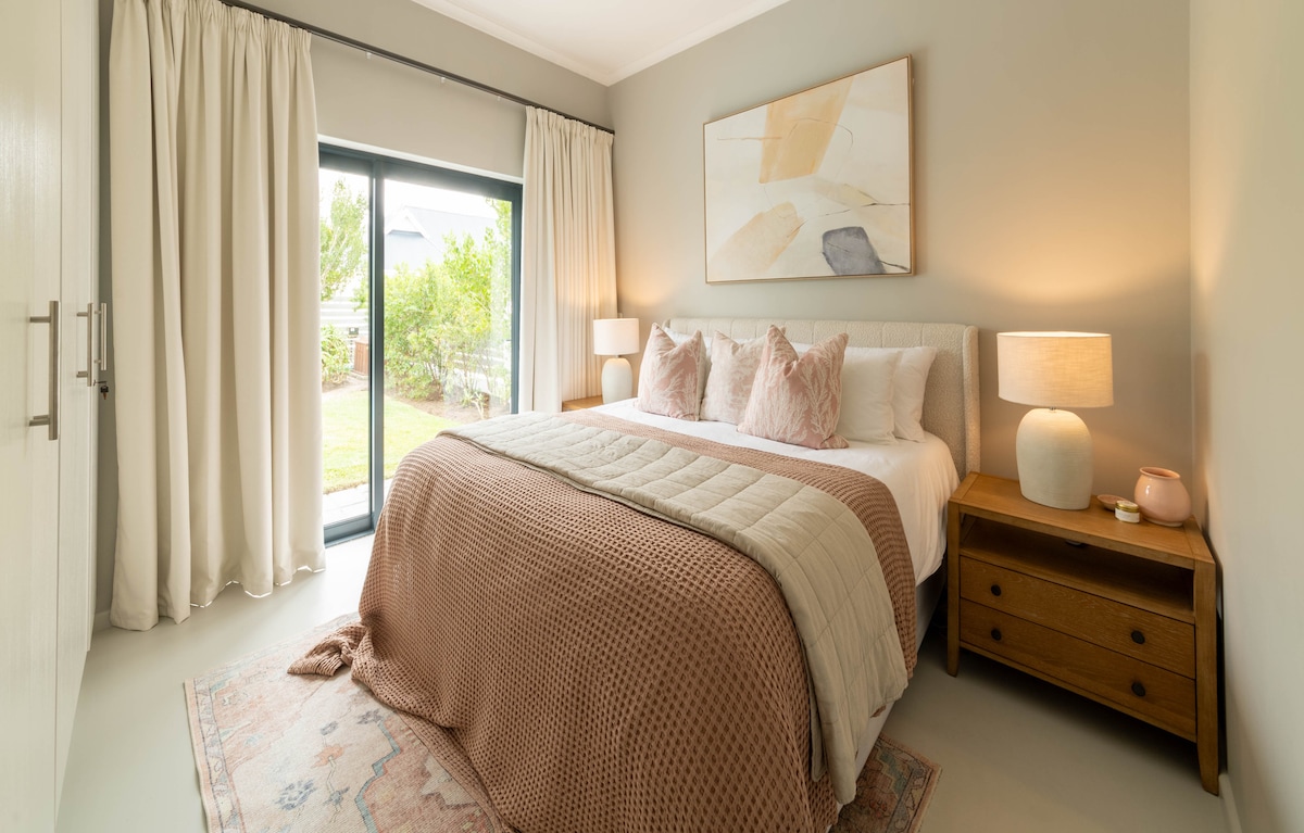 主卧室设有充足的橱柜空间、套房浴室、大镜子和滑动门，可直接进入后花园。 非常舒适的加大双人床、遮光窗帘和吊扇，确保您度过完美的夜晚。