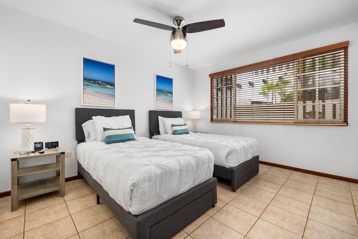 Stylish twin bedroom with two cozy beds, modern decor, and a peaceful view. Great for friends, kids, or family stays.  Beds can be joined to create another King upon request.