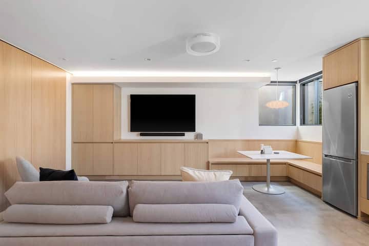 Sala de estar de la unidad del sótano con un sofá cama tamaño queen de alta gama y muy cómodo y TV inteligente.