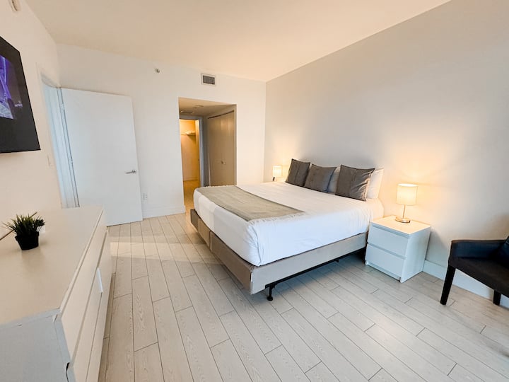 Dormitorio principal con cama tamaño king e iluminación brillante.